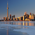 Man standing on frozen Lake Ontario ice looking at Toronto city 